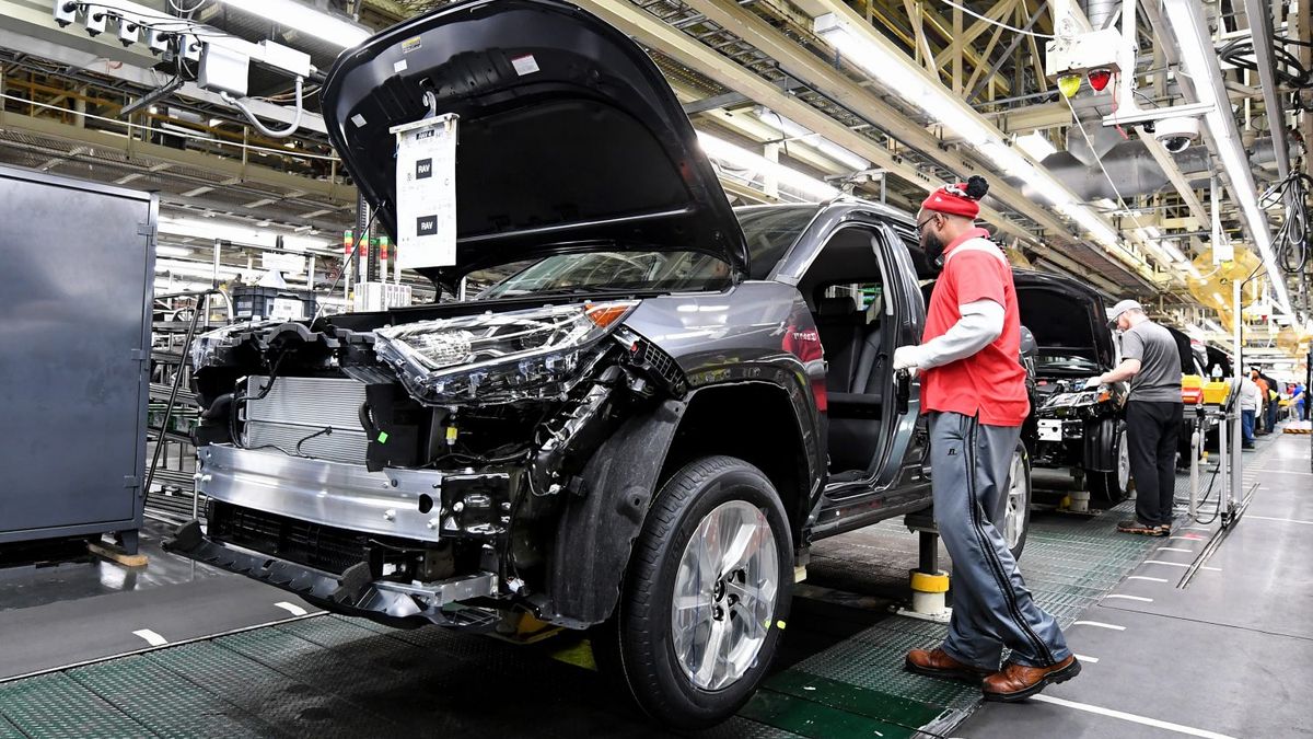 A worker at Toyota Motor Manufacturing, Kentucky inspects a vehicle on the assembly line.
