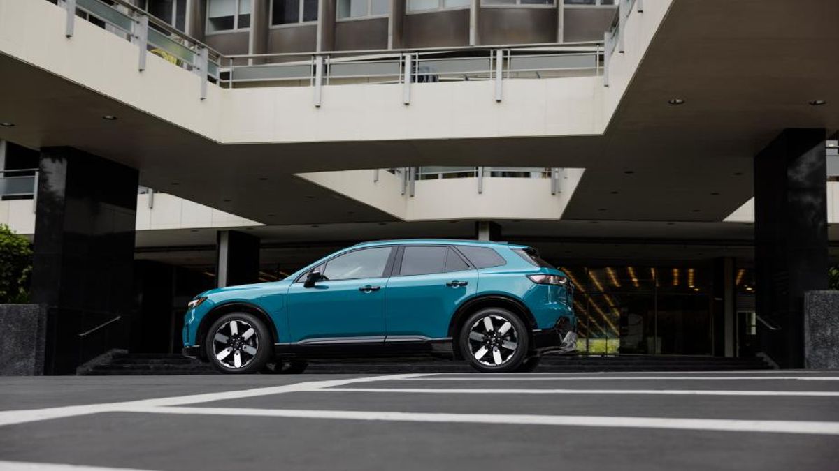A bright blue Honda Prologue SUV is parked in front of an apartment building