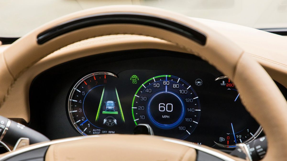 A steering wheel light bar and cluster icons on a car dashboard indicates the status of Super Cruise.