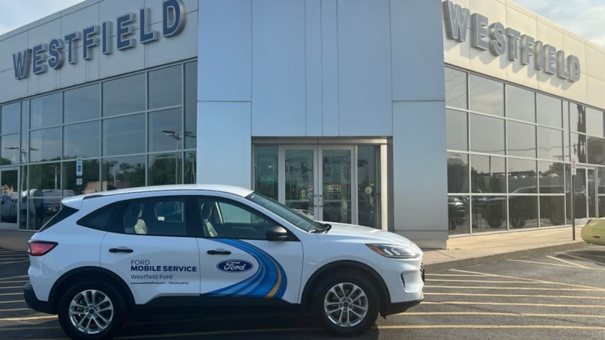 A Ford Escape mobile service truck sits in front of a dealership