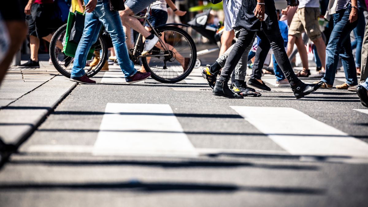 Pedestrians and cyclists cross a crosswalk.