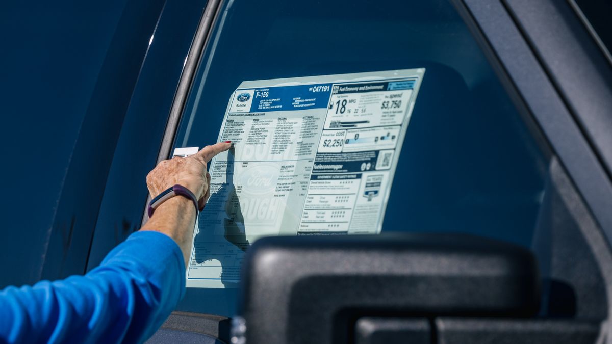 A customer inspects the Monroney sticker on a Ford vehicle at dealership in Houston, Texas.