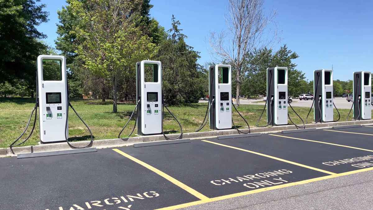 A row of electric vehicle chargers in a parking lot.