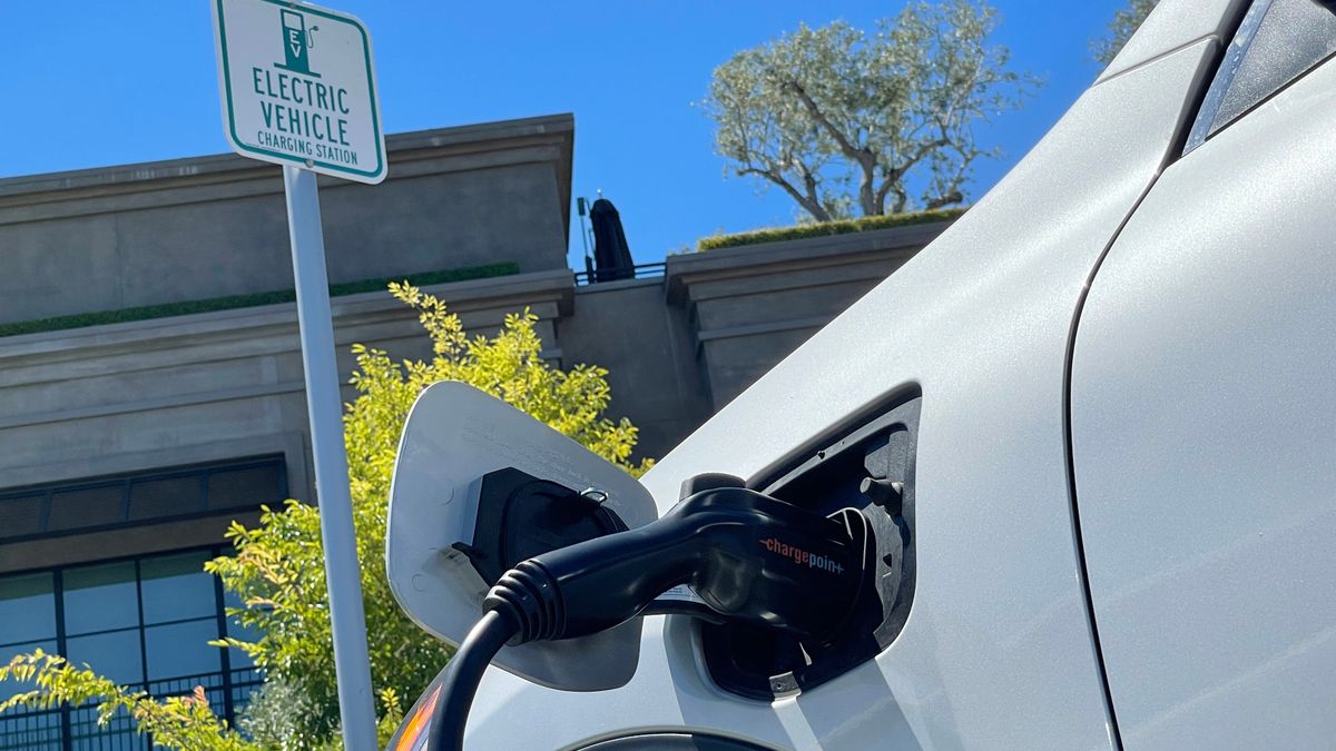 An electric car charges at a mall parking lot.