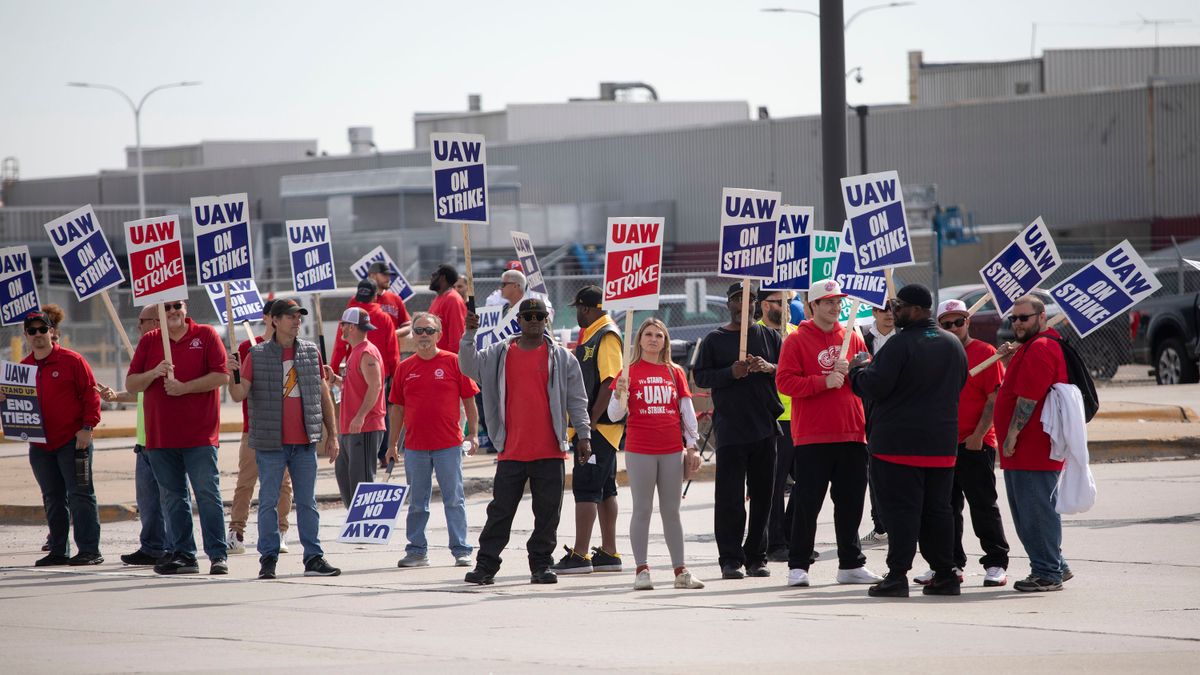 A group of UAW members hold strike signs outside of Ford's Michigan Assembly Plant in Wayne, Michigan.